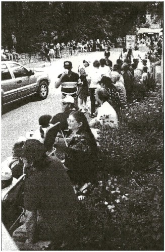 Cheering squad lines up on wall in front of church awaiting the arrival of our float.